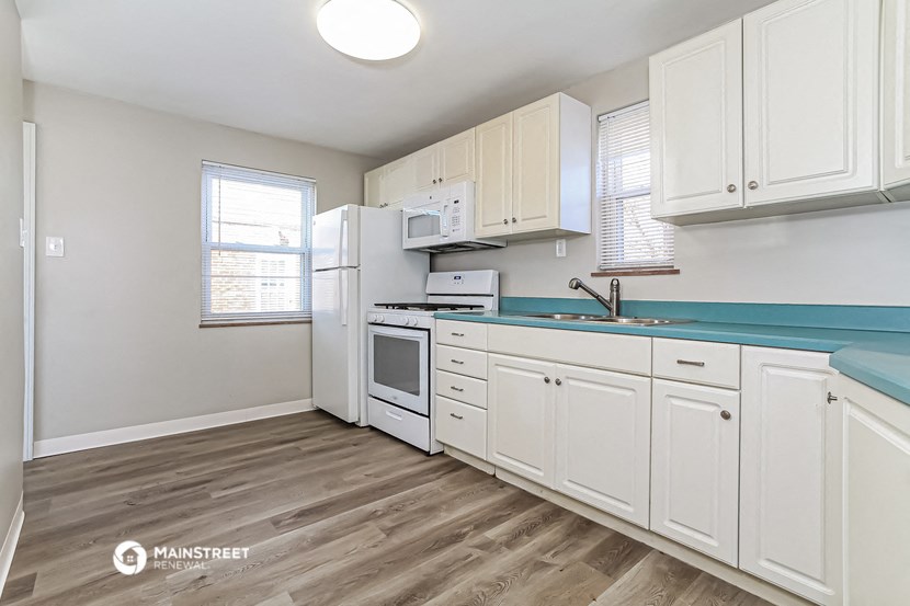 a kitchen with white cabinets and a sink and a refrigerator