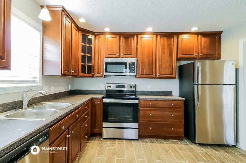 a kitchen with wooden cabinets and stainless steel appliances