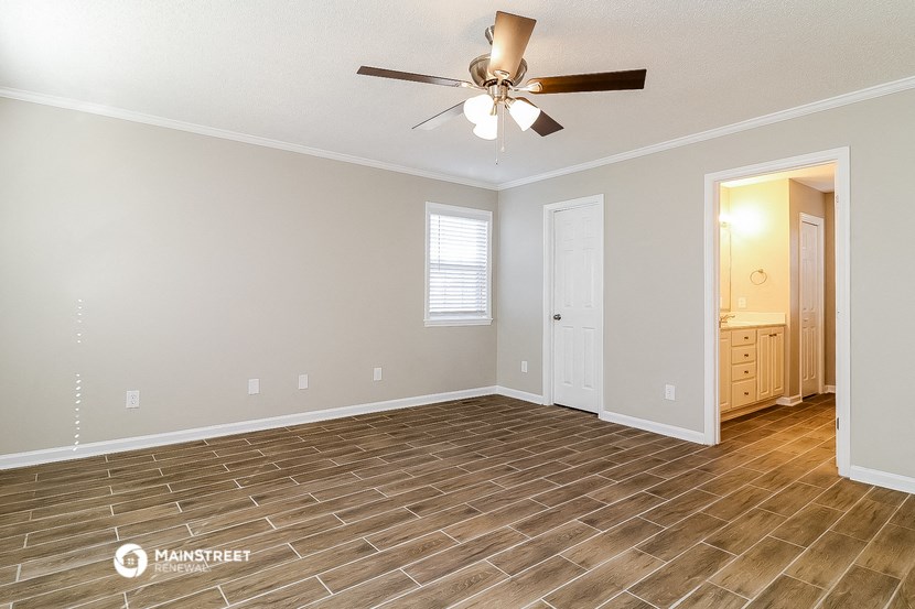 the living room with wood flooring and a ceiling fan