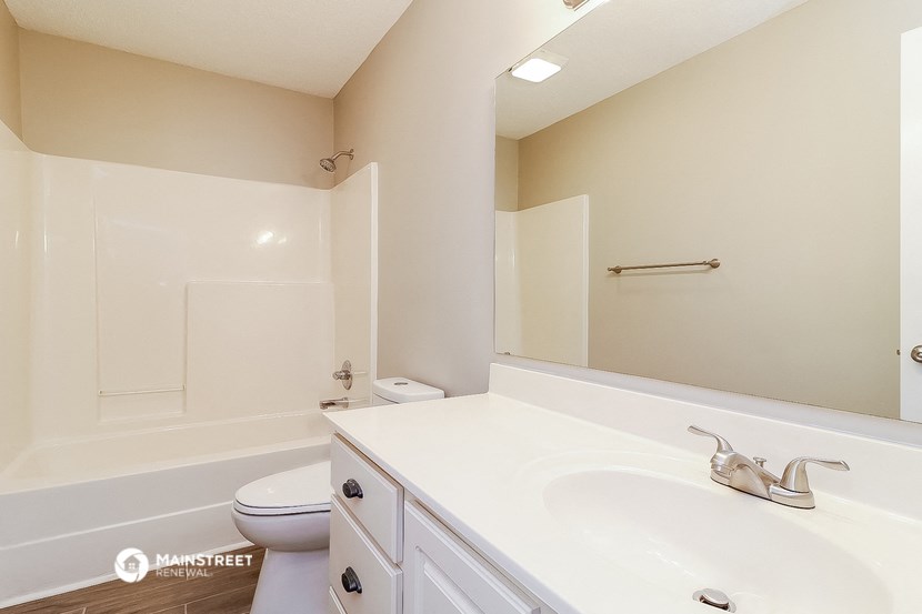 a bathroom with a large mirror and a sink and a toilet
