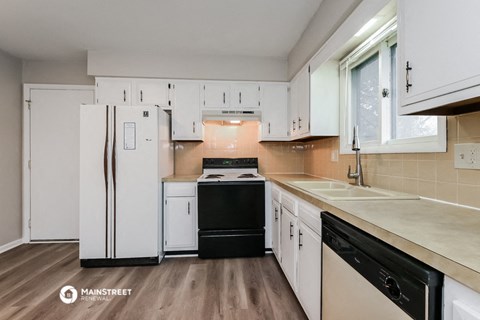 a kitchen with white cabinets and a black stove and refrigerator