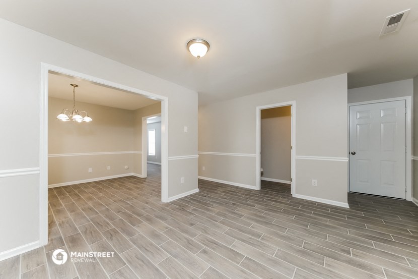 the living room and dining room in a new home with wood flooring