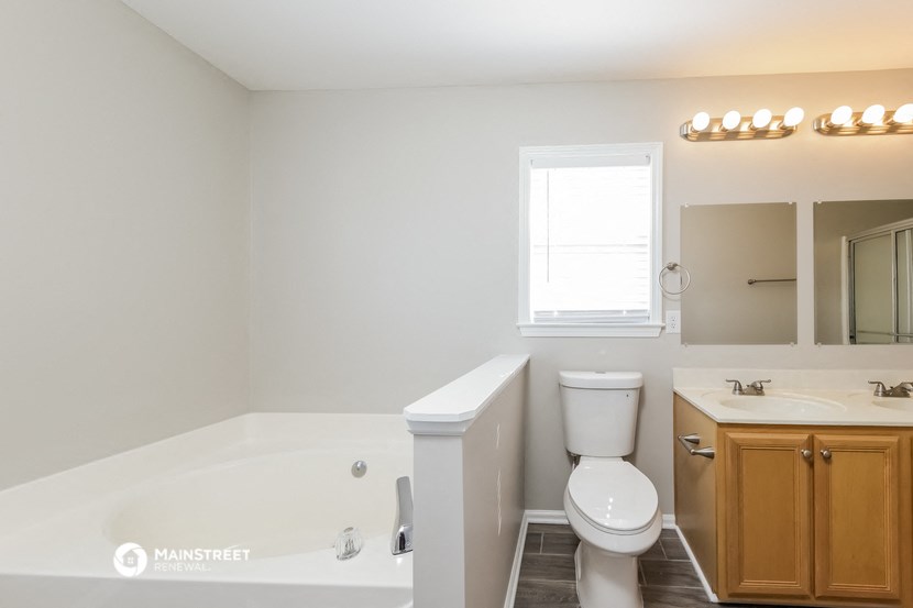 a white bathroom with a toilet and a tub and a sink