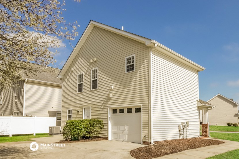 a white house with a garage and a driveway