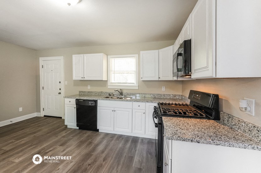 the kitchen of an apartment with white cabinets and granite counter tops
