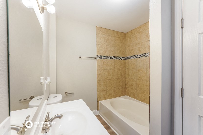 a bathroom with a tub and a sink and a mirror