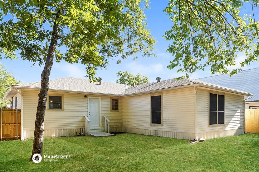 a white house with a yard and a tree