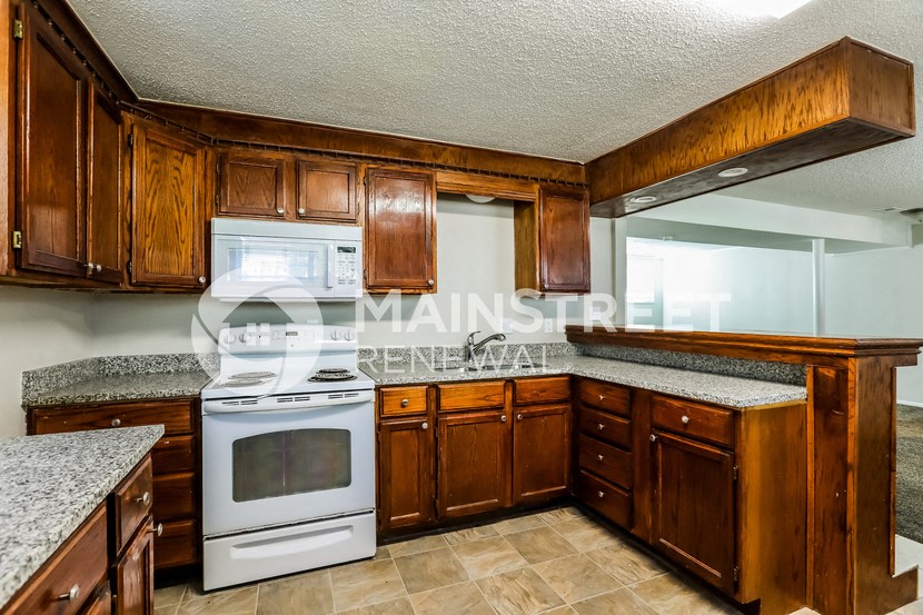 a kitchen with wood cabinets and white appliances