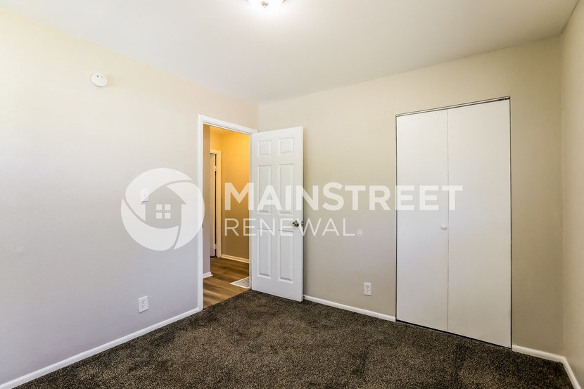 a bedroom with a closet and a door to a hallway
