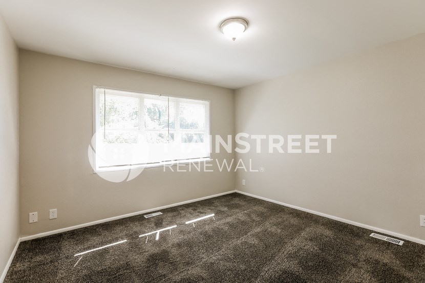 a living room with carpet and a window