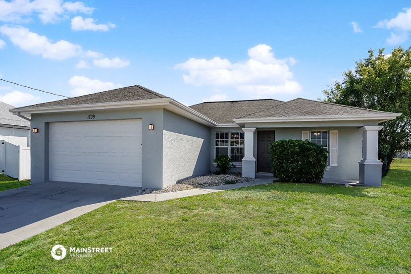 a white house with a lawn and a white garage door