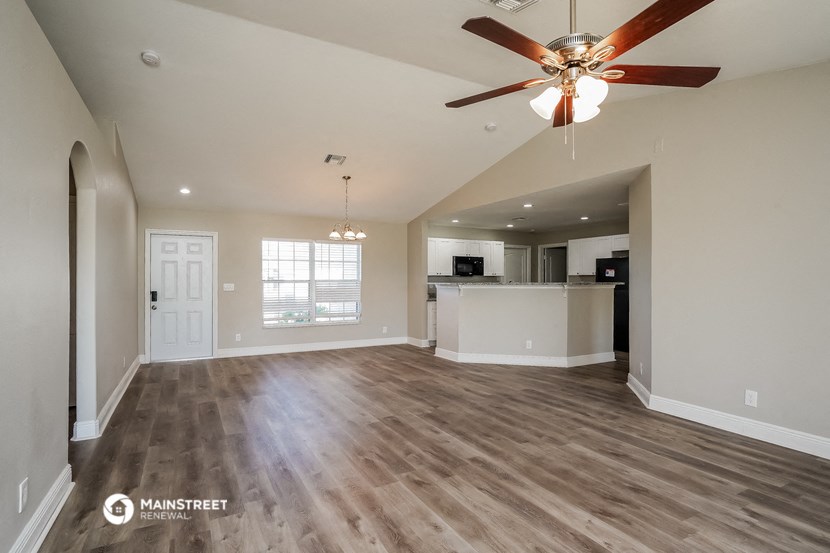 an open living room and kitchen with a ceiling fan