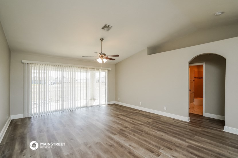 a living room with a ceiling fan and a large window