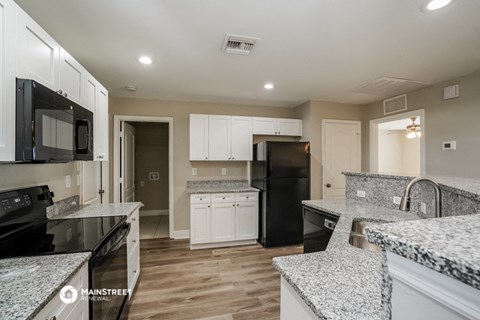 a kitchen with granite counter tops and black appliances
