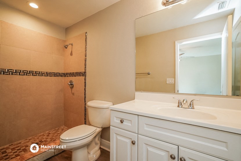 a bathroom with a toilet and a sink and a mirror