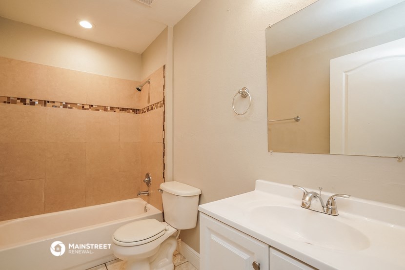 a bathroom with a sink toilet and tub and a mirror