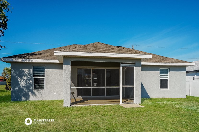 a small white house with a porch and a lawn