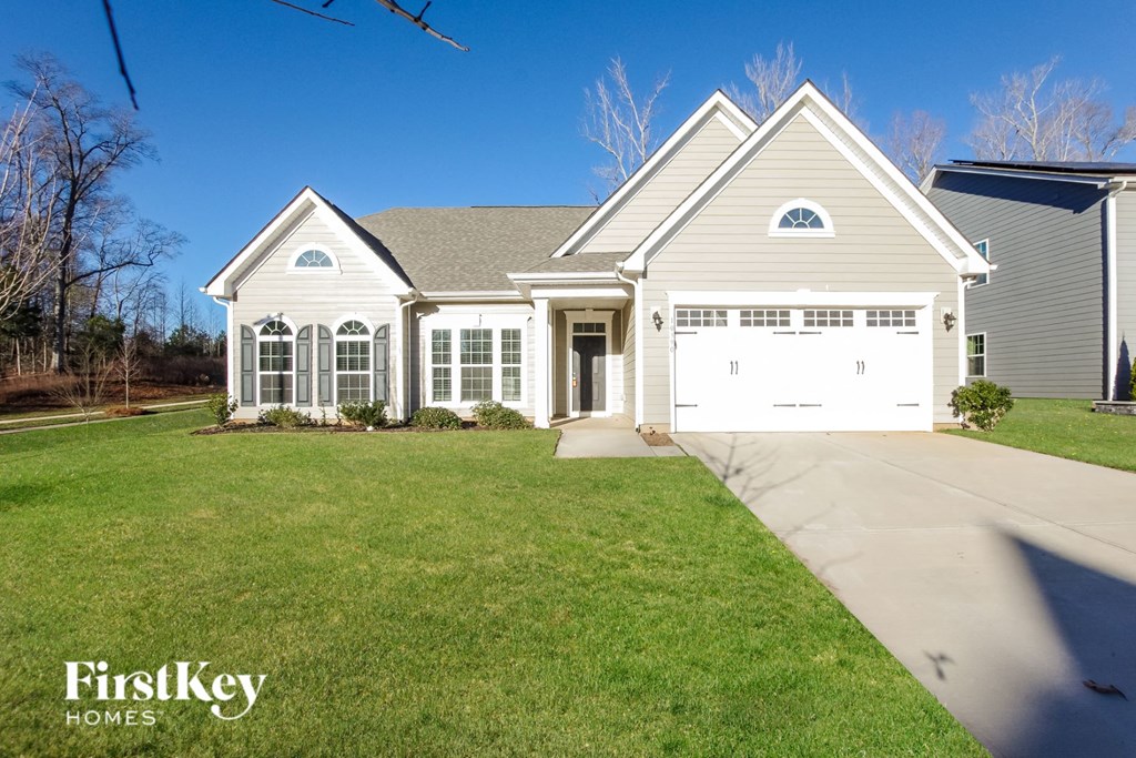a white house with a white garage door and a lawn