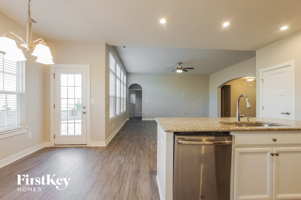 an empty kitchen and living room with a sink and a dishwasher