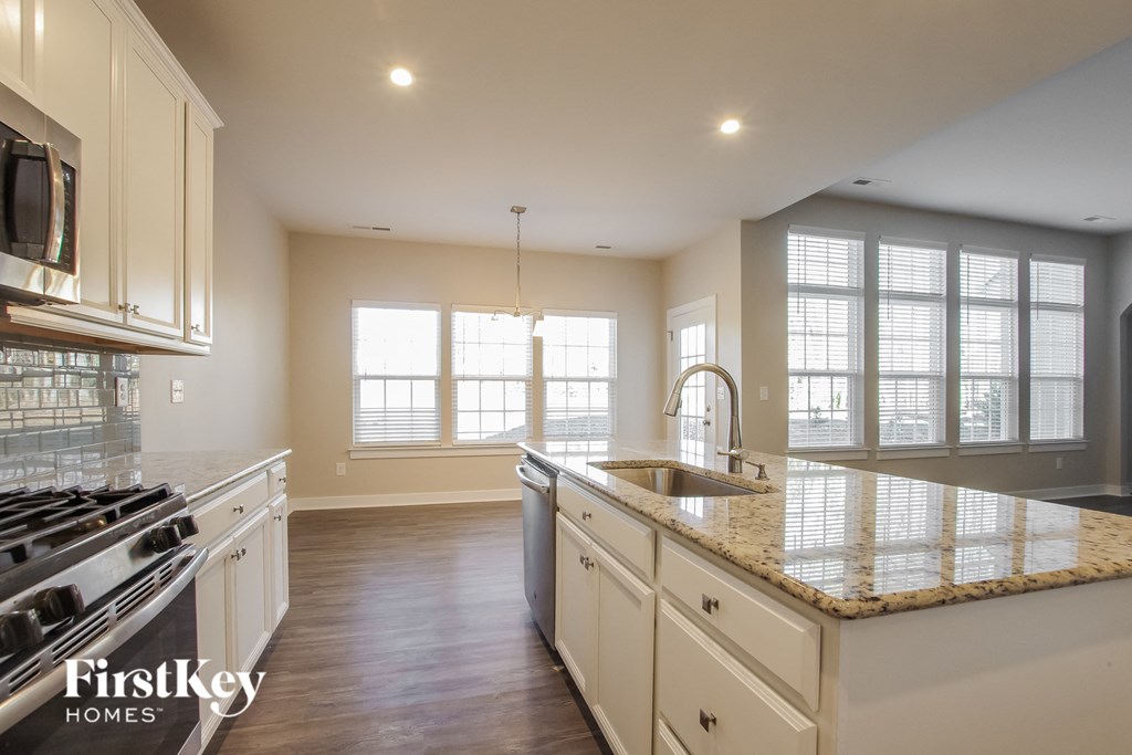 a large kitchen with white cabinets and granite counter tops