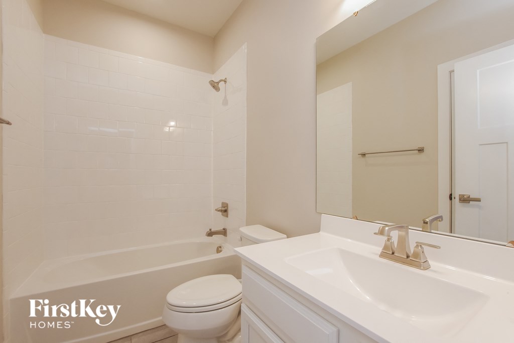 a bathroom with a sink toilet and tub and a mirror