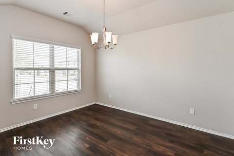 the spacious living room with wood flooring and a large window