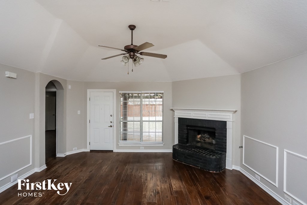 A room with a fireplace and a ceiling fan.