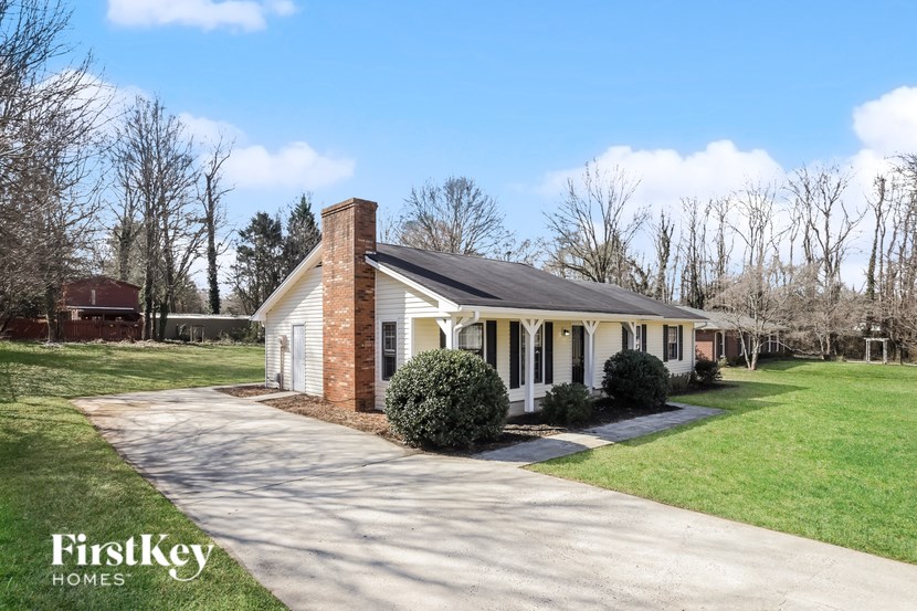 A house with a brick chimney is for sale by FirstKey Homes.