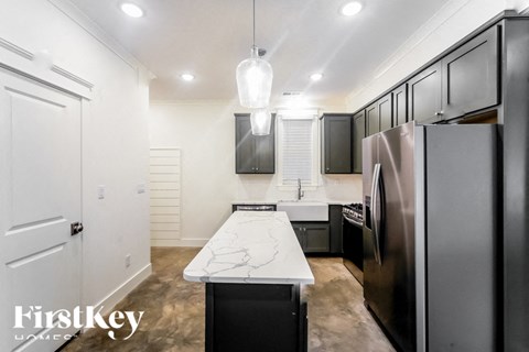 A modern kitchen with a marble table and stainless steel appliances.