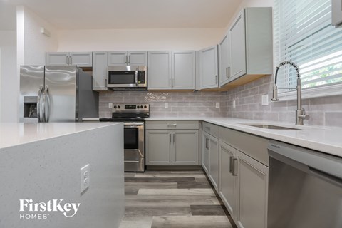 a modern kitchen with white cabinets and stainless steel appliances