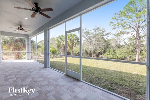 a patio with sliding glass doors and a grass field