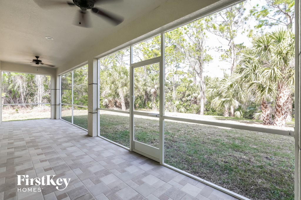 a covered patio with a view of the yard and trees