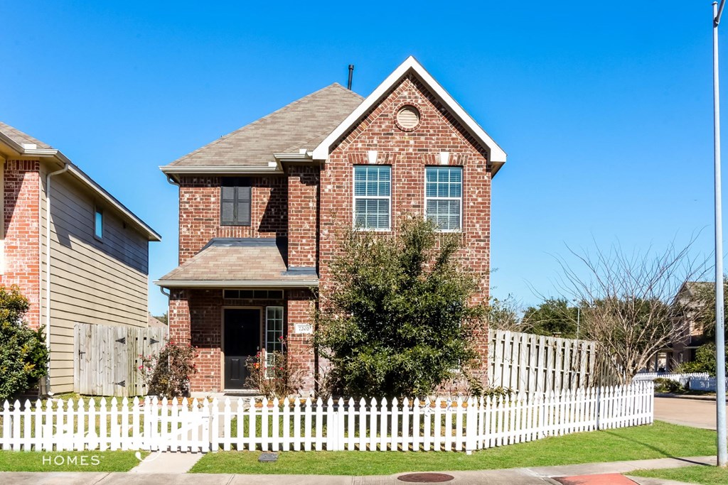 a house with a white picket fence in front of it