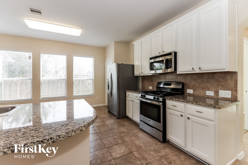 a kitchen with white cabinets and stainless steel appliances