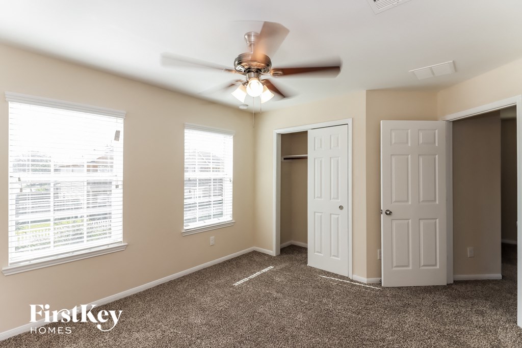 a bedroom with a ceiling fan and a closet