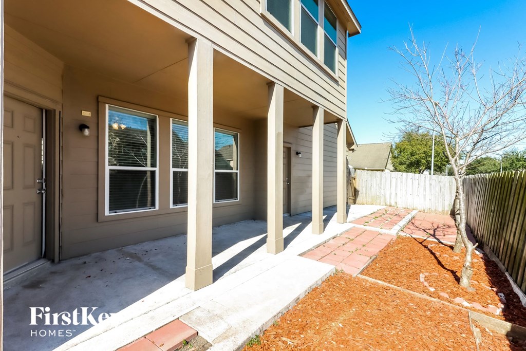 the front porch of a home with columns and a walkway