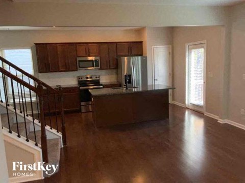A kitchen with wooden cabinets and a stainless steel refrigerator.