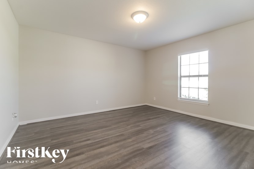 A room with wooden flooring and a window.