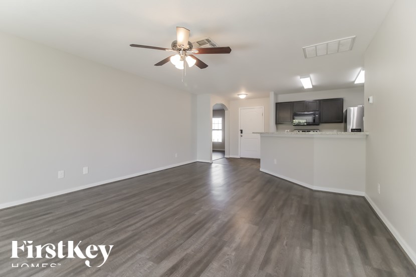 A spacious room with a ceiling fan and wooden flooring.