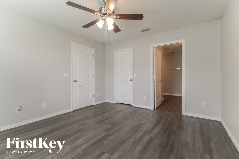 A room with a ceiling fan and wooden flooring.