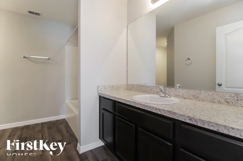 A bathroom with a marble countertop and a white sink.