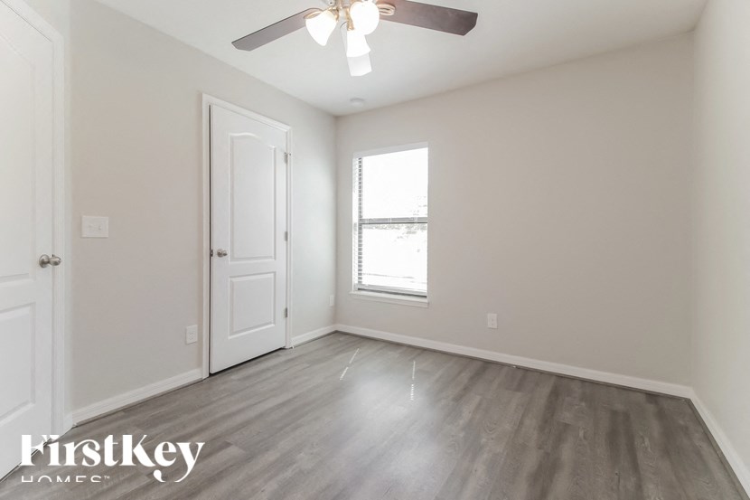 A room with a wooden floor and a ceiling fan.
