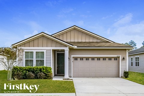 A house with a garage and a driveway in front of it.