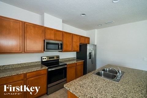 A kitchen with brown cabinets and a granite countertop.