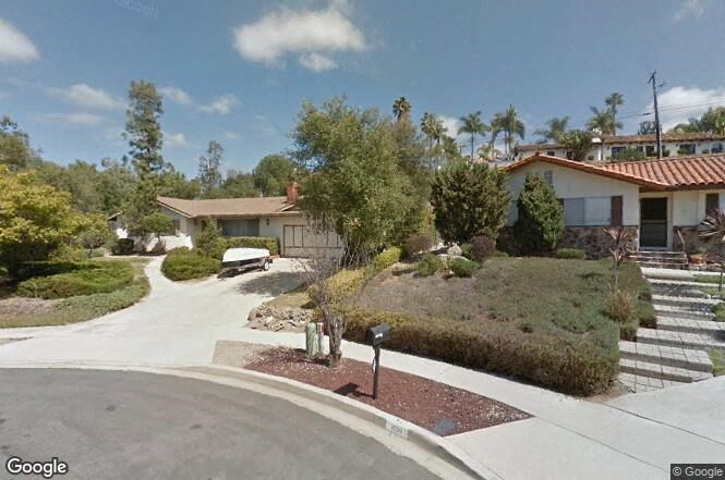 a house in a neighborhood with a driveway and trees
