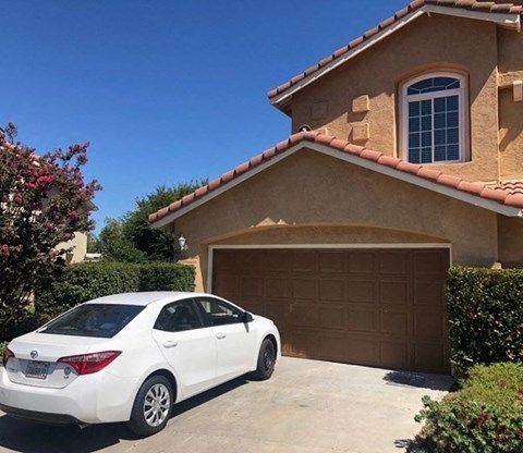 a white car parked in front of a house