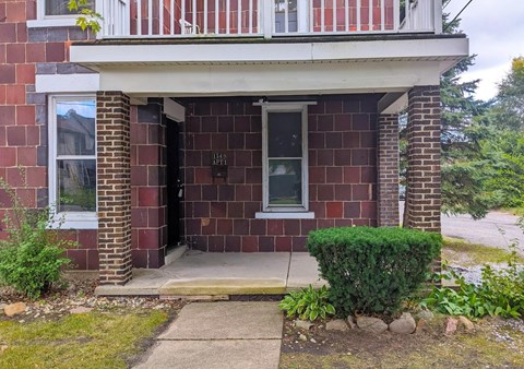 the front of a brick house with the door open