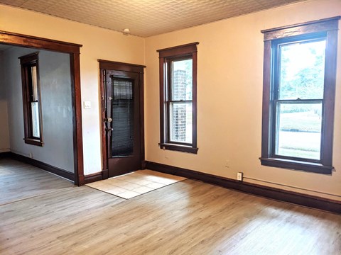 a living room with wood floors and a door and windows