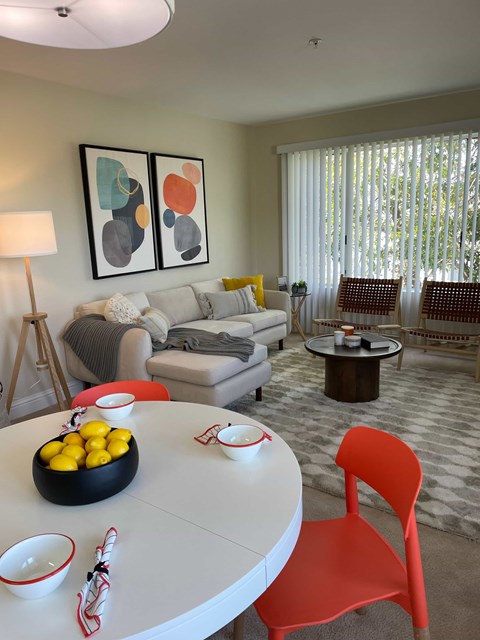 A living room with a white table and a red chair.