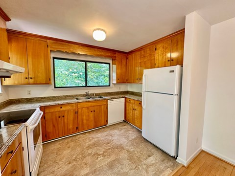 A kitchen with wooden cabinets and a white refrigerator.